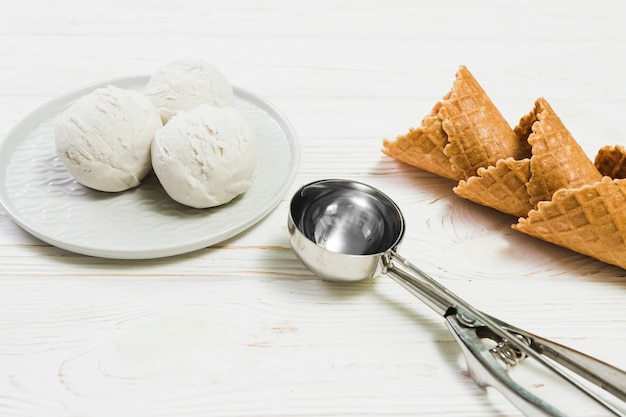 Foto gratuita scoop cerca de bolas de helado y conos de waffle