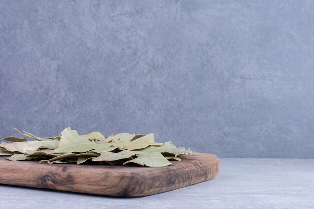 Secar las hojas de laurel verde en una bandeja de madera. Foto de alta calidad