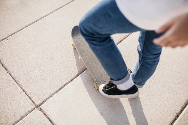 Foto gratuita sección baja de un hombre parado en patineta