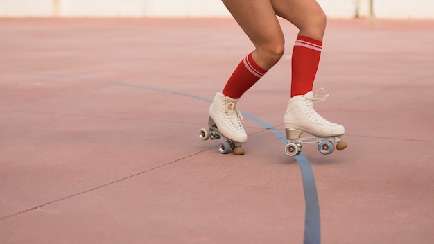 Foto gratuita sección baja de una mujer patinando sobre patines.