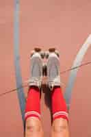 Foto gratuita sección baja de una patinadora con calcetines rojos y patines.