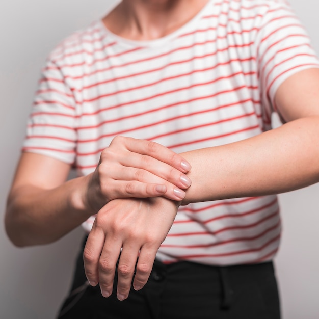 Foto gratuita sección media de una mujer joven con dolor en la muñeca