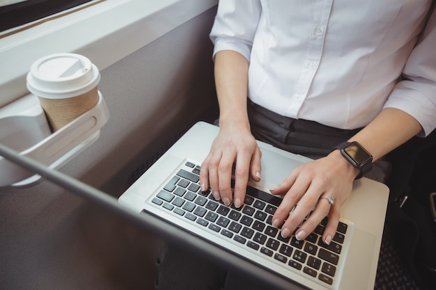 Sección media de mujer usando laptop