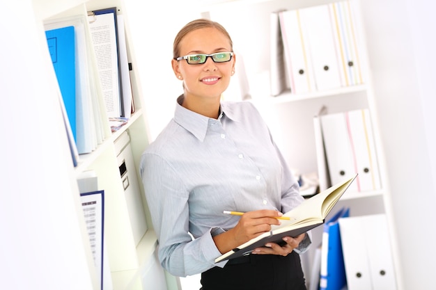 Foto gratuita secretaria sonriente con el cuaderno abierto