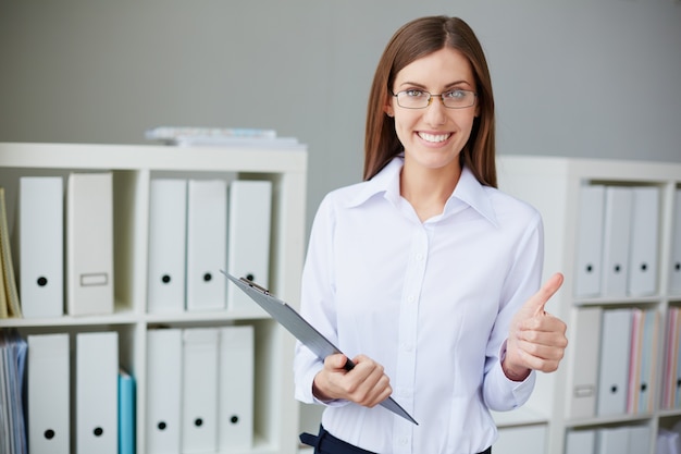 Secretaria sonriente con gafas y pulgar hacia arriba