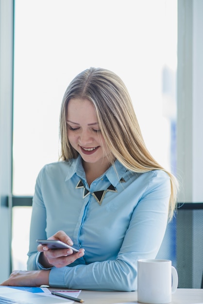 Secretaria sonriente con smartphone