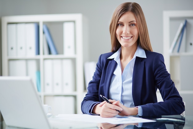 Secretaria sujetando un bolígrafo