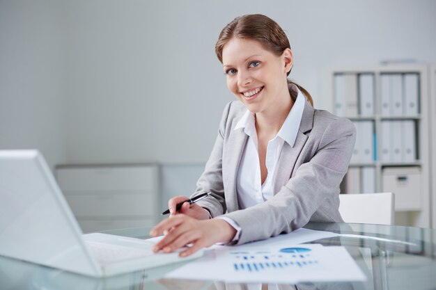 Secretaria trabajando con documentos estadísticos