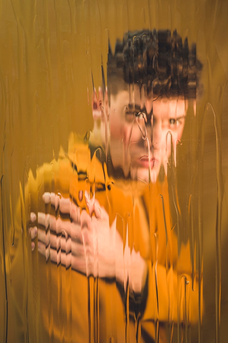 Photo Gratis seductive model looking at the camera behind wet glass