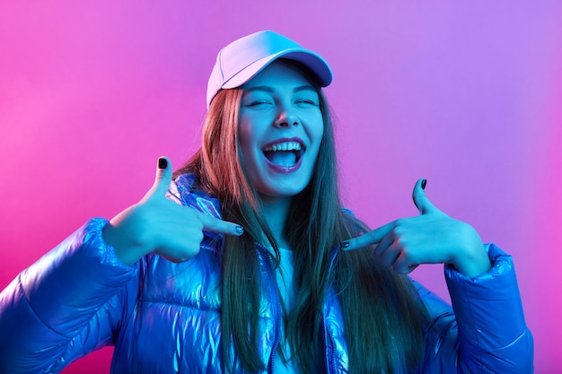 Foto gratuita segura feliz emocionada mujer vistiendo chaqueta y gorra de béisbol