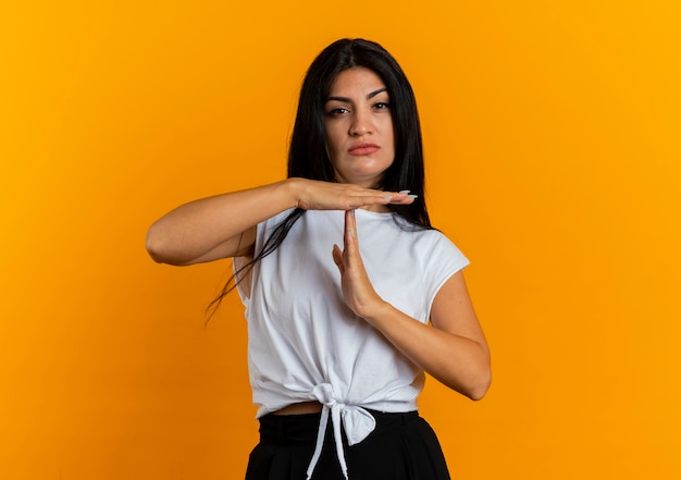 Segura joven mujer caucásica gesticulando tiempo fuera signo de mano