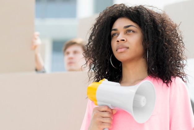 Segura mujer con cabello rizado protestando