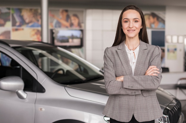 Segura mujer posando delante de un coche