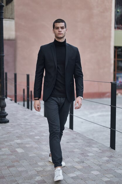 Seguro joven caminando en una calle de la ciudad europea