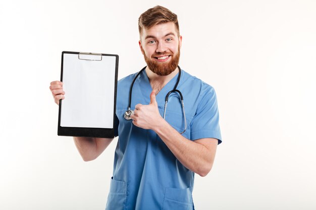 Seguro médico joven sosteniendo portapapeles y dando pulgar