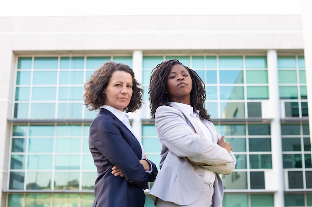 Foto gratuita seguros colegas femeninas mirando a cámara