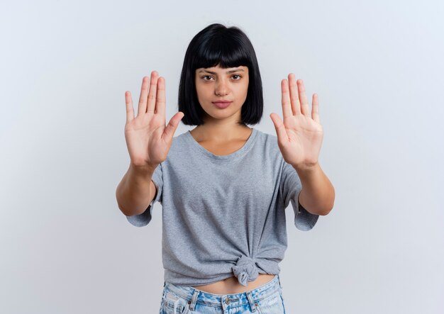 Seguros de joven morena mujer caucásica gestos dejar de firmar la mano con las dos manos