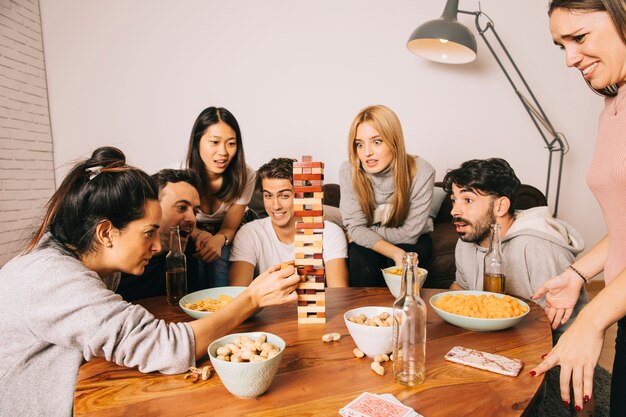 Seis amigos alegres jugando juego de mesa