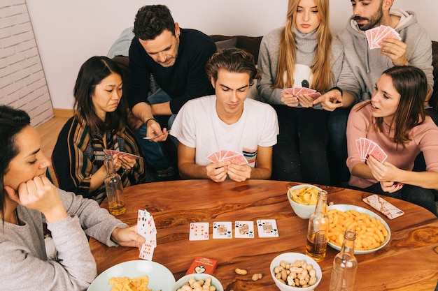 Seis amigos jugando a las cartas