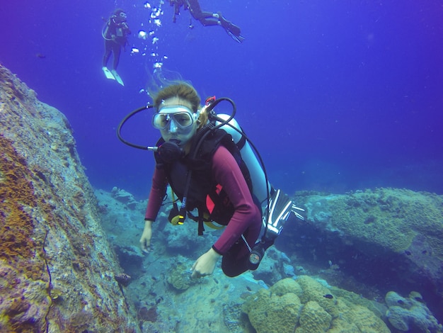 Selfie buceo submarino disparó con selfie stick. Profundo mar azul. Gran angular disparo.