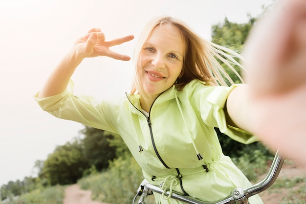 Foto gratuita selfie de una mujer feliz en bicicleta