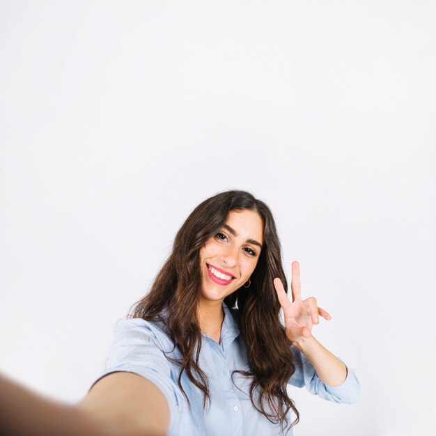 Selfie de mujer haciendo gesto de peace