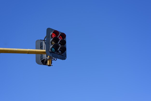 Semáforo rojo en el fondo del cielo azul