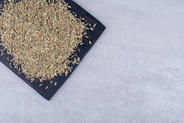 Semillas de anís secas en un plato sobre fondo de hormigón. Foto de alta calidad