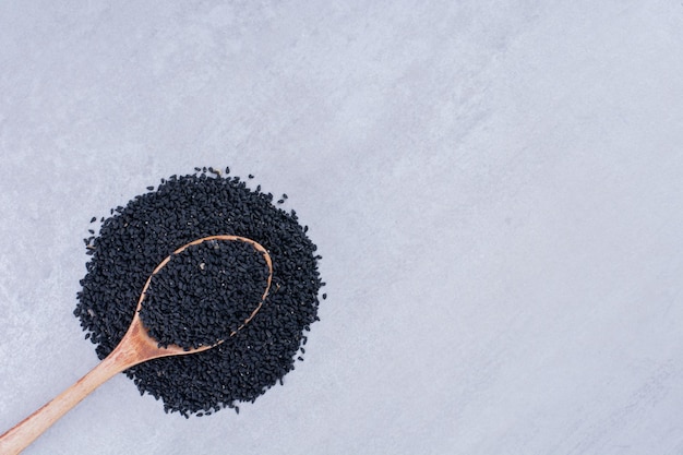 Foto gratuita semillas de comino negro en una cuchara de madera. foto de alta calidad