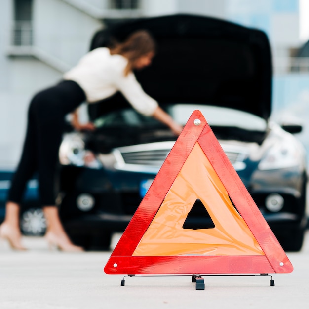 Foto gratuita señal de emergencia con coche en segundo plano.