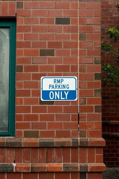 Señal de estacionamiento en vista frontal de la pared de ladrillo