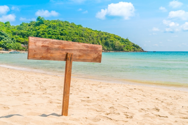 Señal de madera en la playa tropical