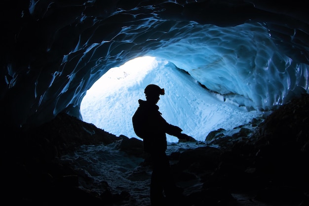 Senderismo masculino solitario en las montañas en una jaula cubierta de nieve durante el día