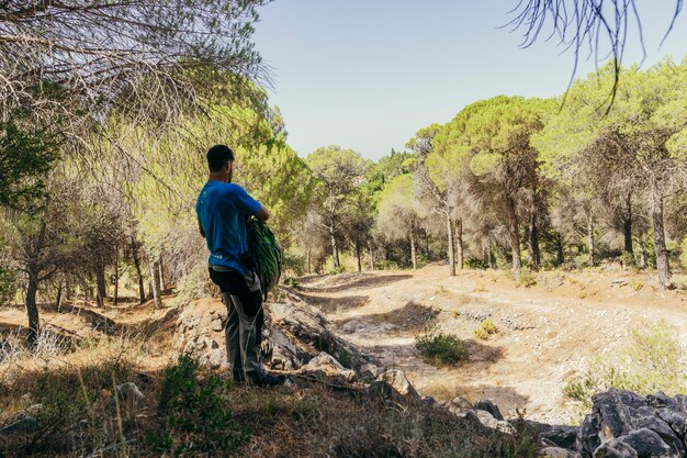 Senderista en bosque sujetando mochila