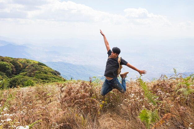 Senderista feliz saltando por el campo