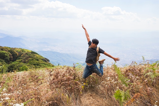 Senderista feliz saltando por el campo