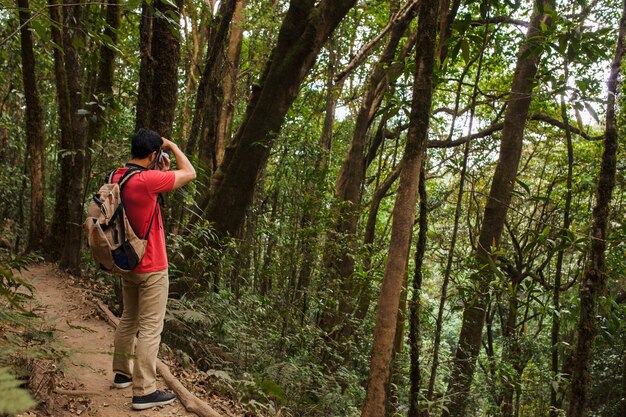 Foto gratuita senderista con mochila haciendo una foto