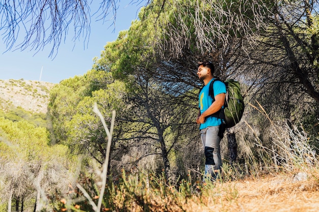 Foto gratuita senderista de pie en bosque