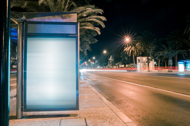 Senderos de luz para autos de carretera en la caja de luz de publicidad de la ciudad moderna