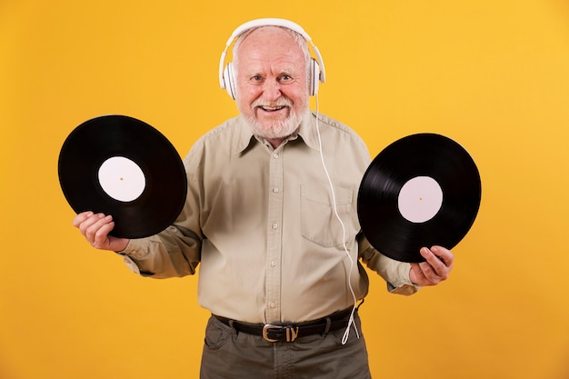 Senior en casa feliz con discos de música