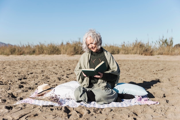 Foto gratuita senior dama leyendo libro al aire libre