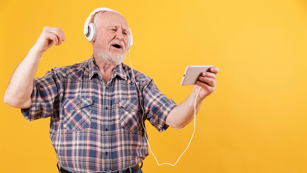 Senior feliz disfrutando de la música en casa