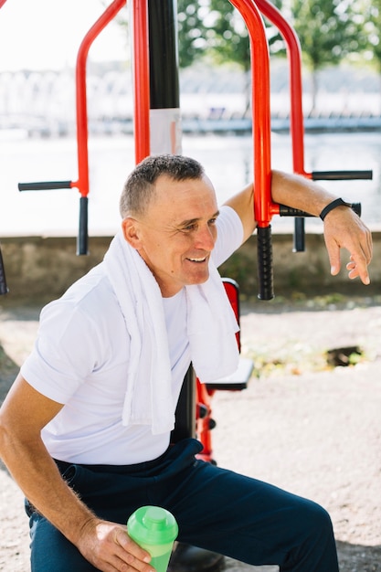 Senior hombre deportivo descansando después de hacer ejercicio