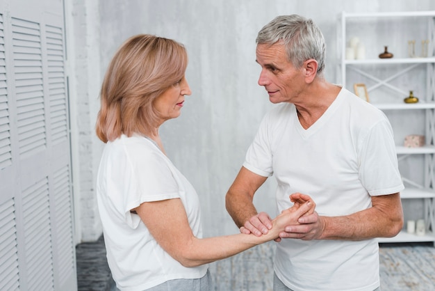 Senior hombre está comprobando el pulso de la mujer