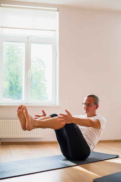 Senior hombre haciendo ejercicios en el gimnasio