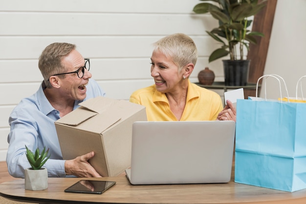 Senior hombre y mujer abriendo sus bolsas y cajas