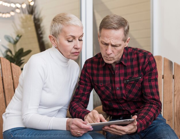 Senior hombre y mujer mirando juntos en una tableta