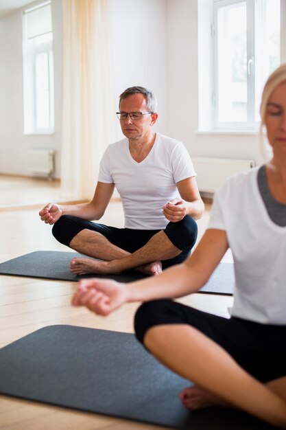 Senior hombre y mujer practicando yoga