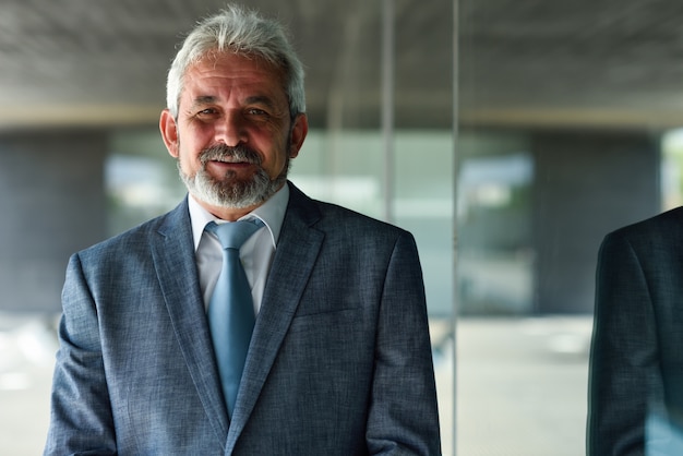 Foto gratuita senior hombre de negocios fuera del edificio de oficinas moderno.