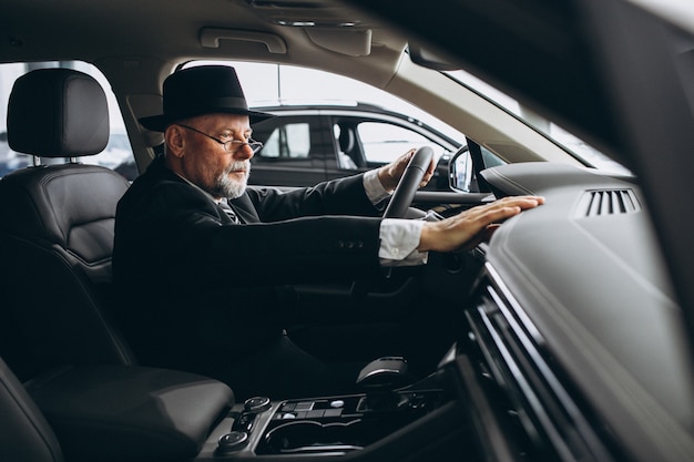 Senior hombre sentado dentro de un auto